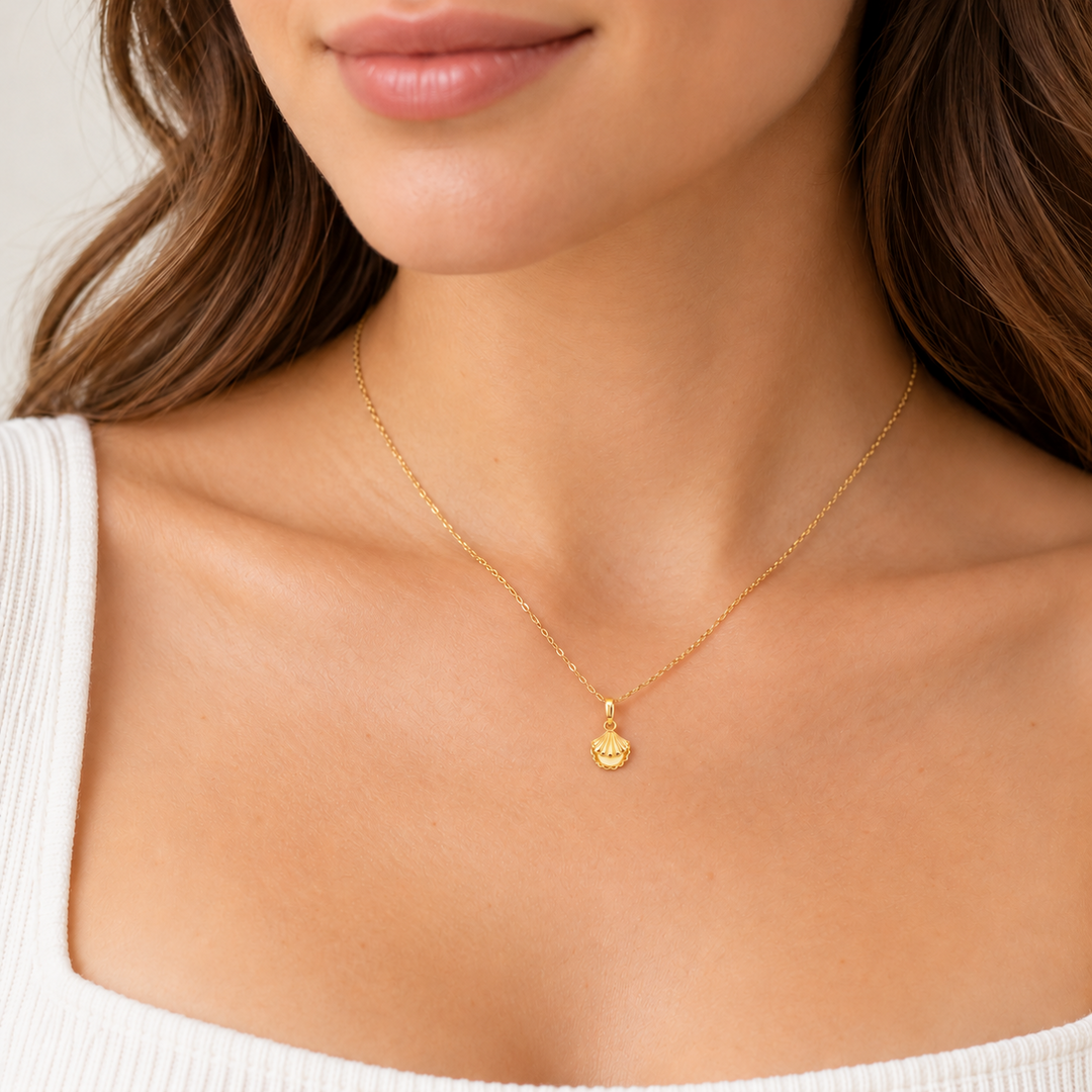 14K yellow gold shell pendant worn on a necklace